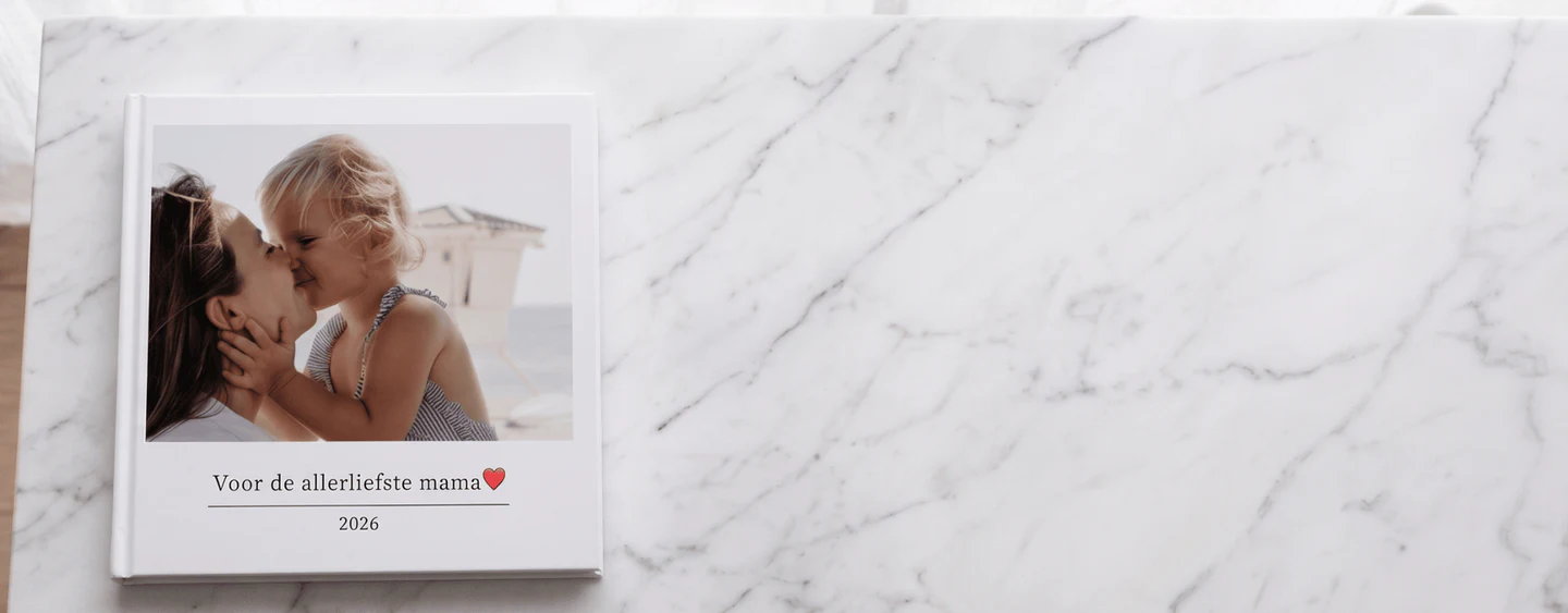 Open lay-flat moederdag fotoboek op een keukentafel met foto's van kleinkinderen